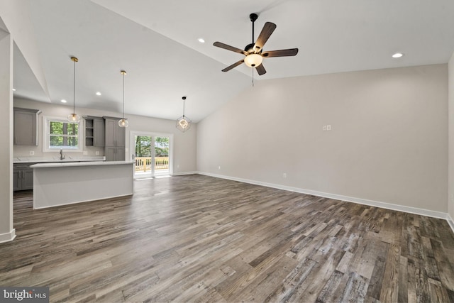 unfurnished living room with ceiling fan, lofted ceiling, sink, and dark hardwood / wood-style flooring