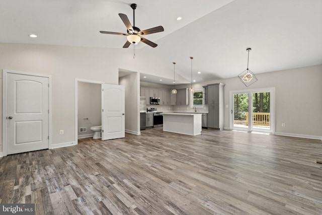 unfurnished living room featuring ceiling fan, high vaulted ceiling, and light hardwood / wood-style floors