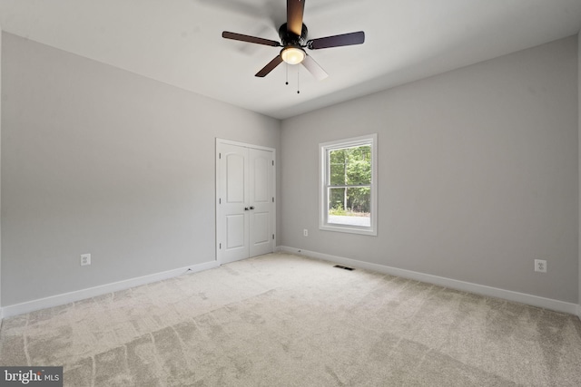 carpeted spare room featuring ceiling fan