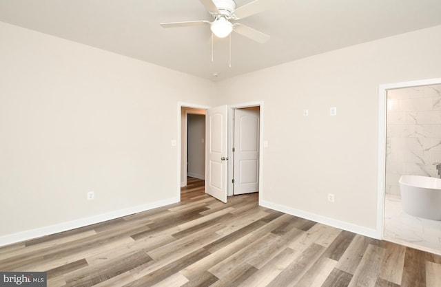 unfurnished bedroom featuring connected bathroom, ceiling fan, and light hardwood / wood-style flooring