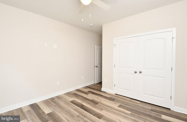 unfurnished bedroom featuring ceiling fan, a closet, and light hardwood / wood-style flooring