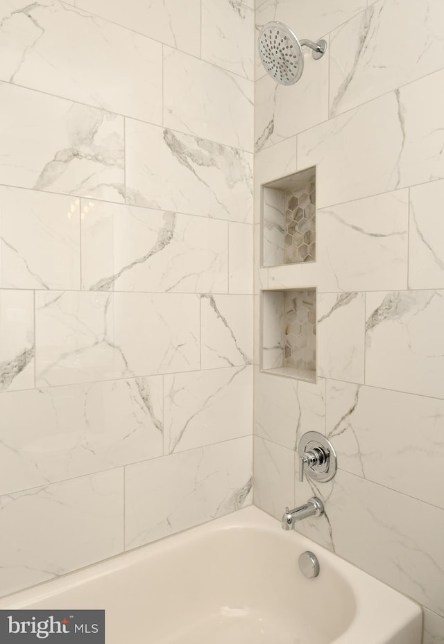 bathroom featuring tiled shower / bath