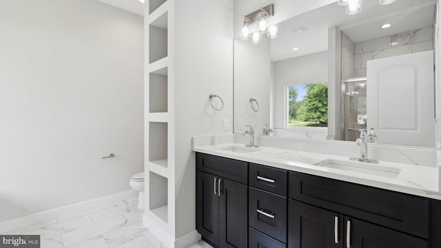 bathroom with vanity, a shower with door, and toilet