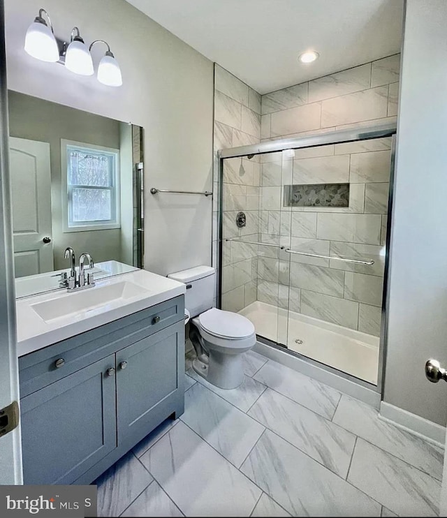 bathroom with an enclosed shower, vanity, and toilet