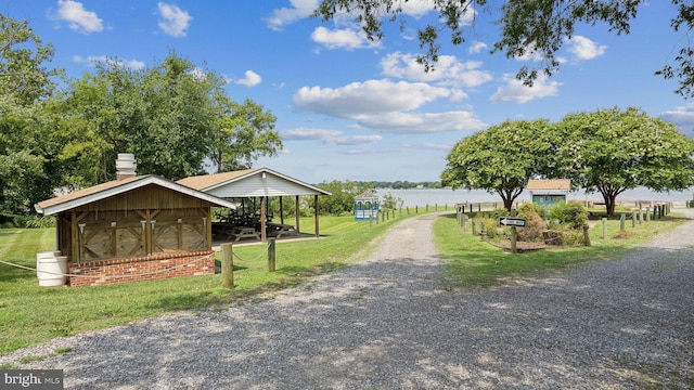 view of home's community featuring a lawn and a water view