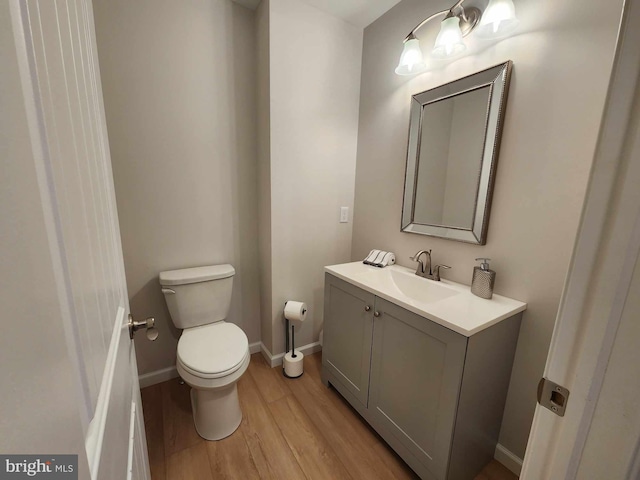 bathroom with vanity, toilet, and hardwood / wood-style floors