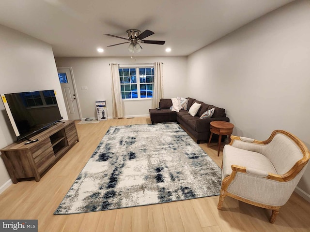 living room featuring light hardwood / wood-style floors and ceiling fan