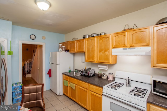 kitchen featuring light tile patterned flooring, sink, and white appliances