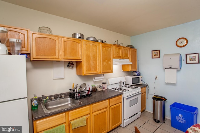 kitchen featuring white appliances, sink, and light tile patterned floors