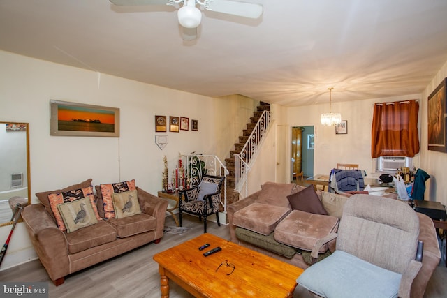 living room featuring cooling unit, ceiling fan with notable chandelier, and light hardwood / wood-style floors