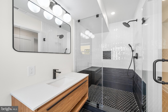 bathroom featuring walk in shower and vanity