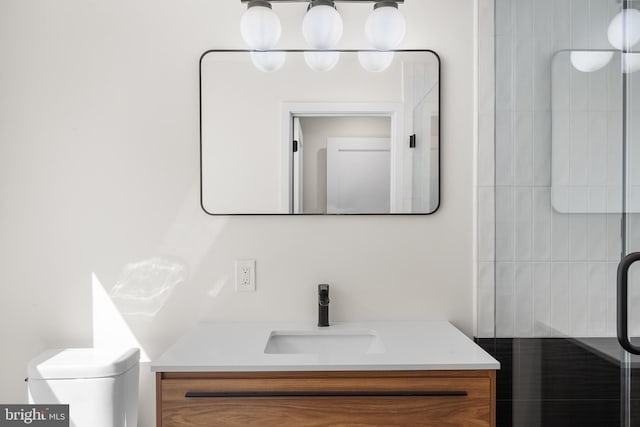 bathroom featuring a shower with shower door, toilet, and vanity