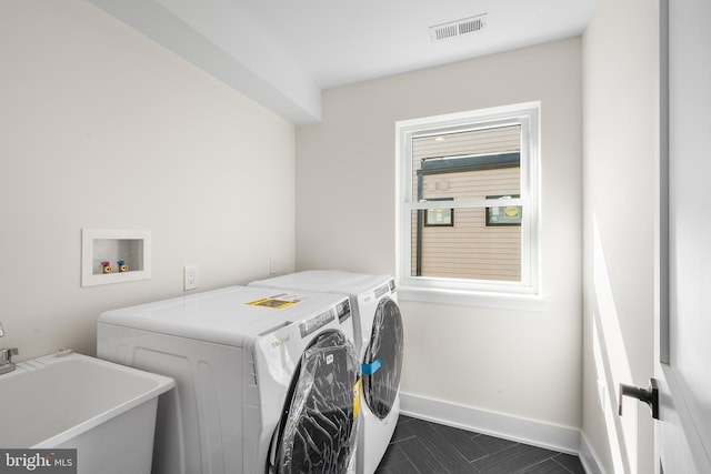 washroom with washing machine and dryer, plenty of natural light, and sink