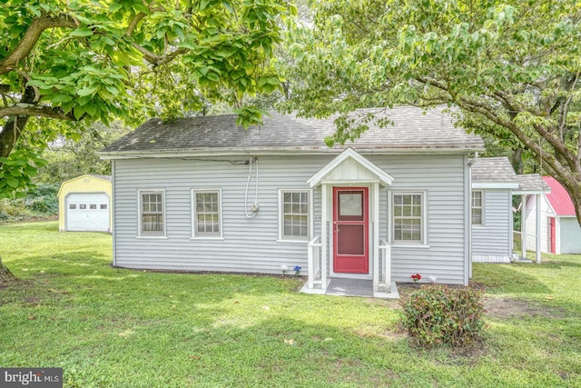 view of front of house with a garage, an outdoor structure, and a front lawn