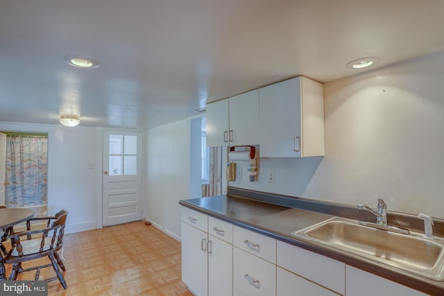 kitchen featuring sink, light parquet floors, and white cabinets