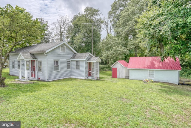 rear view of house featuring an outbuilding and a yard