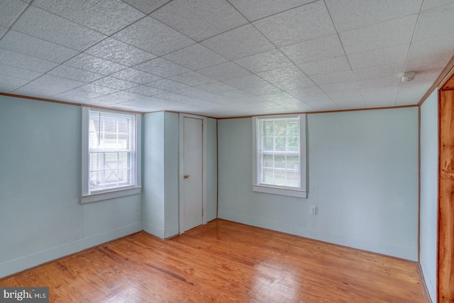 unfurnished bedroom featuring multiple windows and light hardwood / wood-style floors