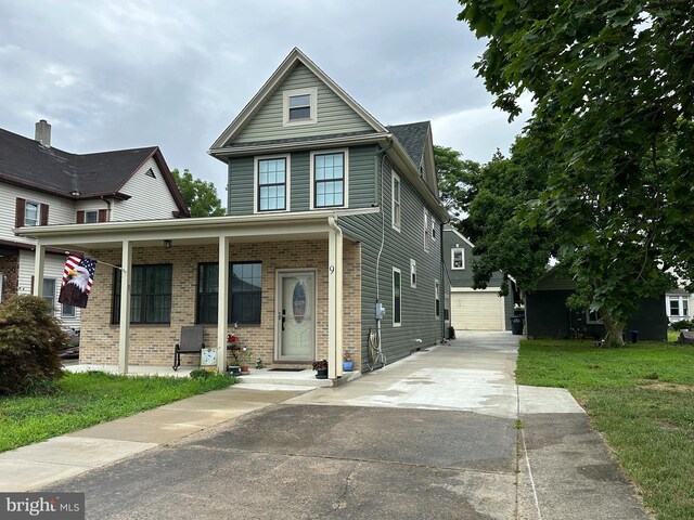 view of front facade featuring an outbuilding, a garage, and a front yard