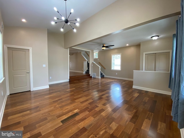 interior space with dark wood-type flooring and ceiling fan with notable chandelier