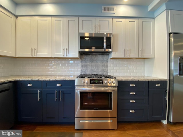 kitchen featuring white cabinetry, stainless steel appliances, tasteful backsplash, light stone counters, and blue cabinets