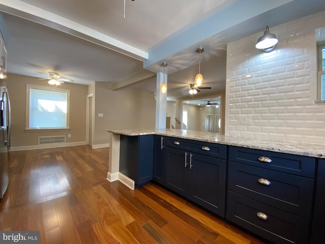 kitchen featuring decorative light fixtures, dark wood-type flooring, decorative backsplash, blue cabinetry, and kitchen peninsula