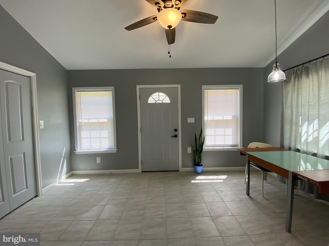 foyer entrance with light tile patterned flooring, ceiling fan, and a wealth of natural light