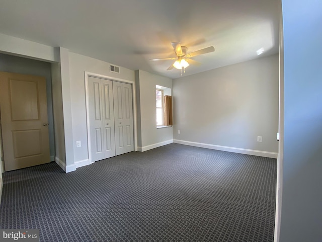 unfurnished bedroom featuring ceiling fan, a closet, and dark carpet