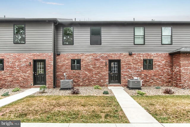 view of front of property featuring a front lawn and cooling unit