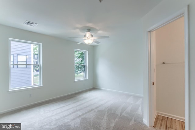 unfurnished room featuring ceiling fan and light carpet