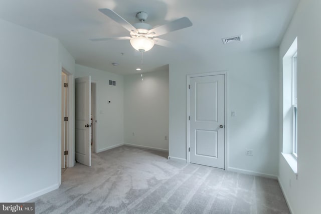 empty room featuring ceiling fan and light carpet