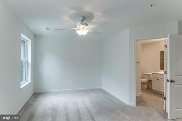 carpeted empty room with ceiling fan and plenty of natural light