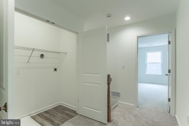 clothes washing area featuring light colored carpet and hookup for an electric dryer