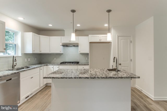 kitchen with pendant lighting, dishwasher, white cabinetry, sink, and a center island with sink