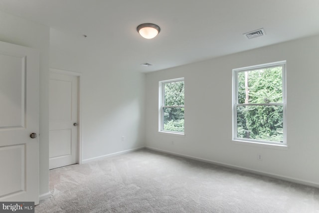 unfurnished room with a wealth of natural light and light carpet