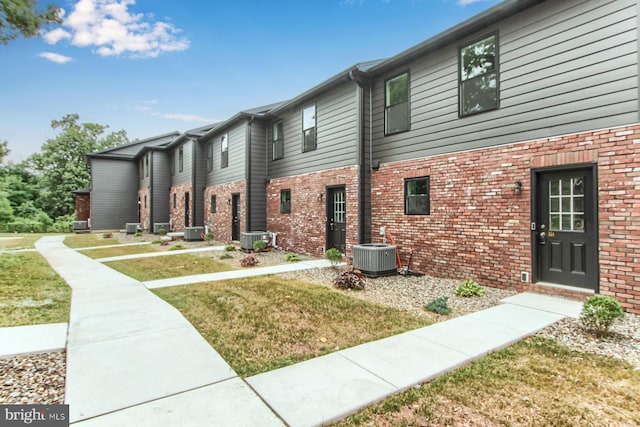 exterior space with a front yard and central AC