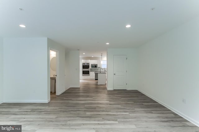 unfurnished living room featuring light hardwood / wood-style floors and sink