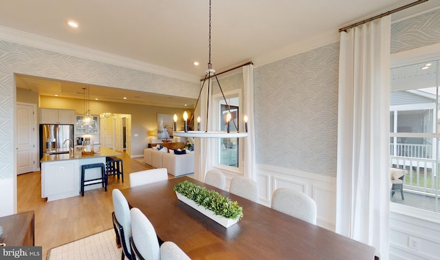 dining room featuring light hardwood / wood-style floors, sink, and crown molding