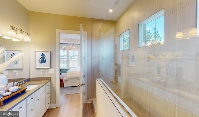 bathroom featuring a tile shower, hardwood / wood-style floors, and vanity