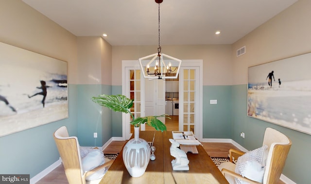 dining area featuring french doors, an inviting chandelier, and hardwood / wood-style flooring