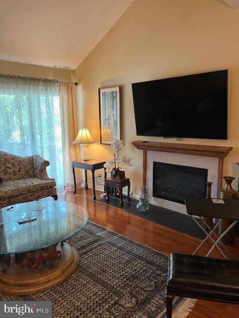 living room with wood-type flooring and vaulted ceiling