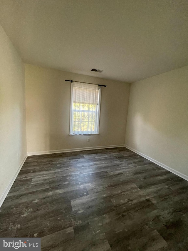 spare room with dark hardwood / wood-style floors