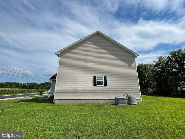 view of side of home featuring a lawn and cooling unit