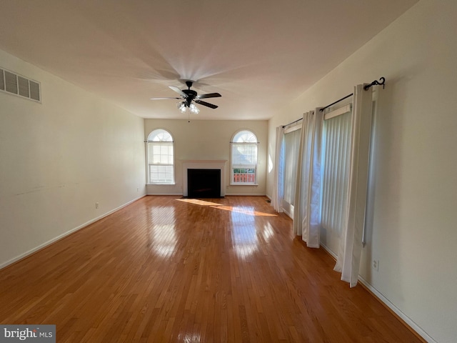 unfurnished living room with ceiling fan and wood-type flooring