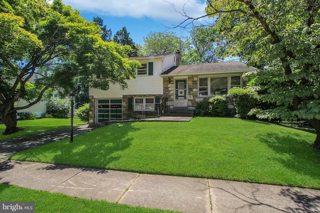 split level home with a garage and a front yard