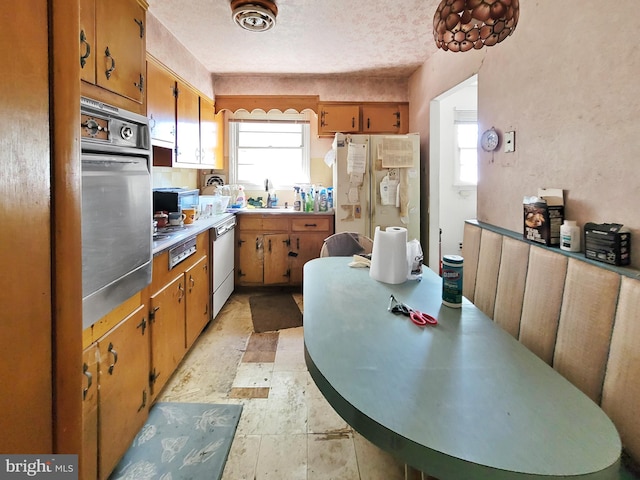 kitchen with sink, appliances with stainless steel finishes, light tile patterned floors, and a textured ceiling