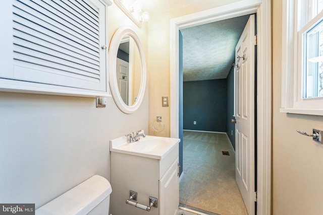 bathroom featuring vanity, toilet, and a textured ceiling