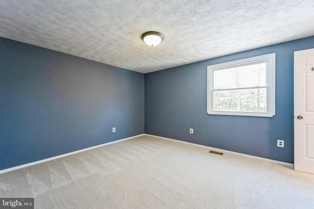 unfurnished room with carpet floors and a textured ceiling