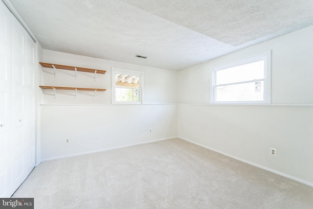 carpeted spare room featuring a textured ceiling