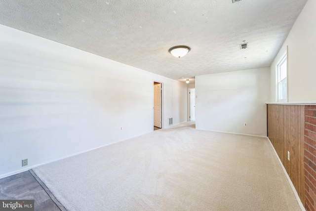 carpeted spare room featuring a textured ceiling