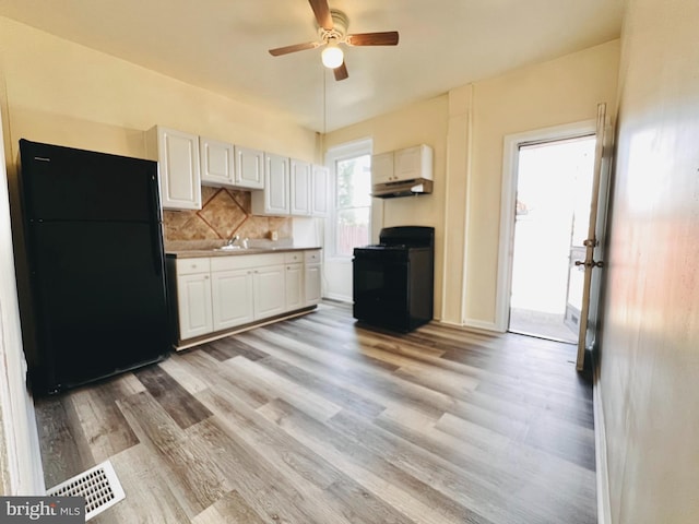 kitchen with white cabinets, black appliances, tasteful backsplash, light hardwood / wood-style floors, and ceiling fan